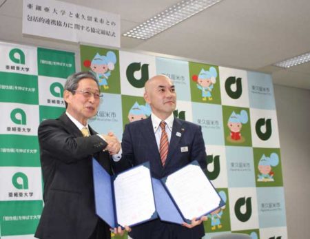 握手を交わす栗田学長（左）と並木市長（東久留米市市役所）